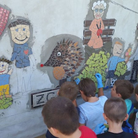 Zdjęcie dzieci układających mozaikę na ścianie budynku MOK - fot. ezg.info.pl