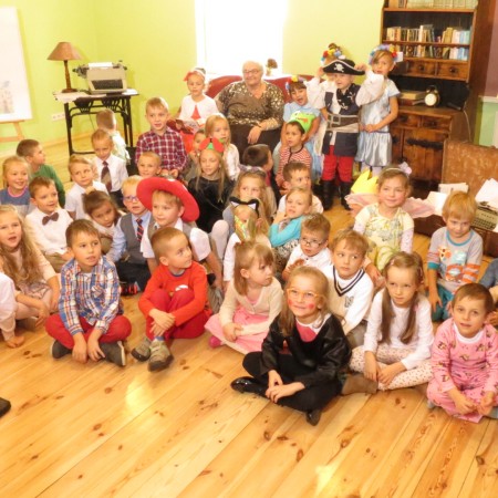 Dzieci uczestniczące w imprezie siedzą na podłodze w Centrum Kultury Dziecka