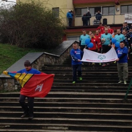Uczestnicy obchodów schodzą po schodach z flagami