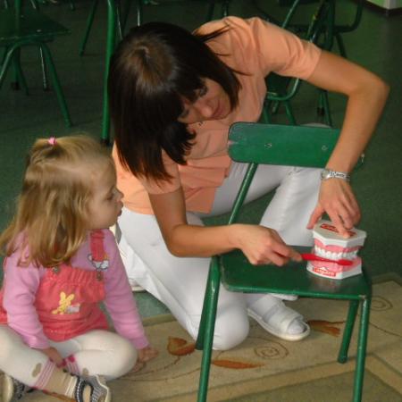 Pani pokazuje dzieciom jak myć zęby