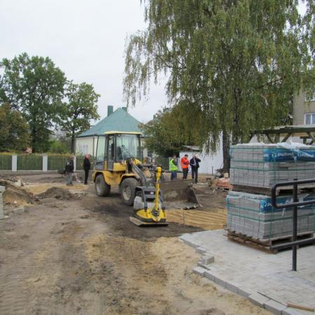 Widok na plac budowy ze sprzętem budowalnym i materiałami