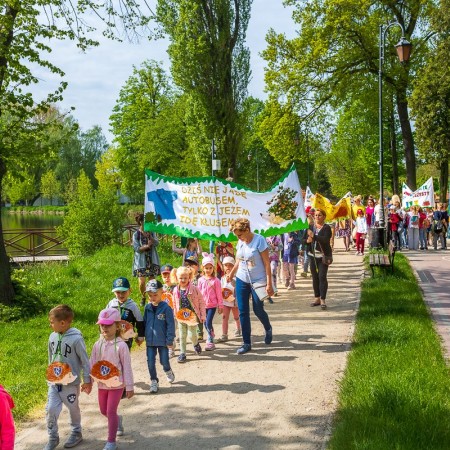 przemarsz dzieci z transparentami w parku miejskim