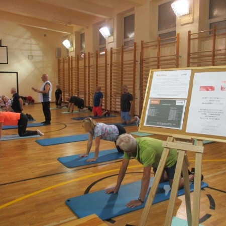 seniorzy uczestniczący w projekcie ćwiczą w sali gimnastycznej