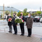 Składanie kwiatów pod tablicami na budynku urzędu masta