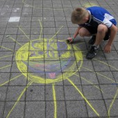 Dziecko rysuje kolorową kredą na chodniku - fot. CKD