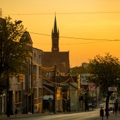 ulica Długa, widok wieży kościoła na tle zachodzącego słońca