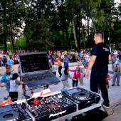 Zdjęcie DJ Tarcza na tle tańczący osób w Parku Miejskim