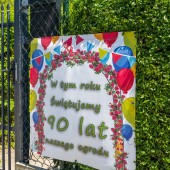 Plakat wisi na ogrodzeniu, przy wejściu do ogródków działkowych